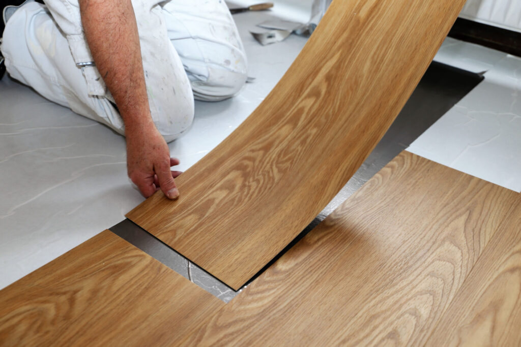 Installer laying a timber-look hybrid plank